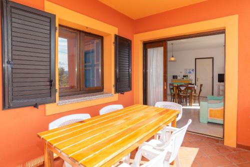 a dining room with a wooden table and chairs at Conchiglia Rosa in Barrabisa