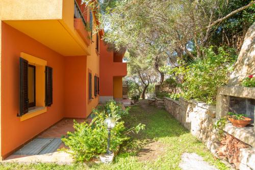an orange house with a garden in front of it at Conchiglia Rosa in Barrabisa