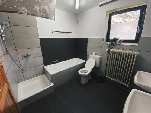 a bathroom with a toilet and a tub and a sink at EcoLodge Bungalow in Oesterdeichstrich