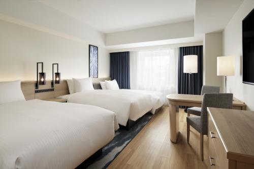 Cette chambre comprend deux lits et un bureau. dans l'établissement Fairfield by Marriott Sapporo, à Sapporo