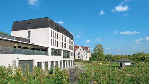 a white building with a black roof at Landhotel Beck in Kupferzell