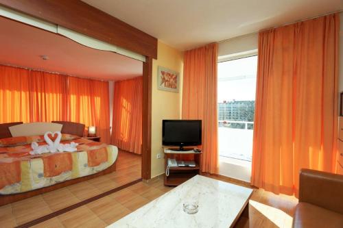 a hotel room with a bed and a television at Hotel Pliska All inclusive in Golden Sands