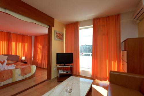 a hotel room with a bed and a television at Hotel Pliska All inclusive in Golden Sands