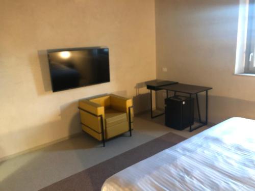 a room with a tv and a chair and a table at Villa Cantoni Marca in Sabbioneta