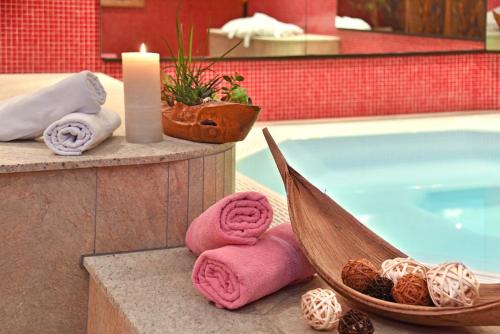 a pool with towels and a hammock next to a swimming pool at Hotel Ranuimüllerhof in Villnoss