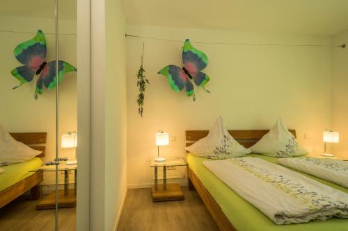 a bedroom with two beds with butterflies on the wall at Ferienwohnung Lavendel in Sipplingen