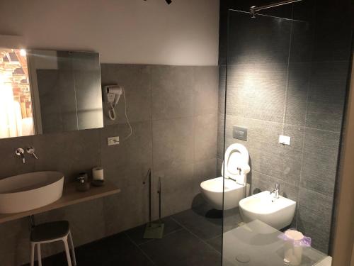 a bathroom with a sink and a toilet and a mirror at Villa Cantoni Marca in Sabbioneta