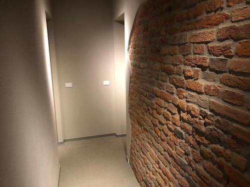a brick wall in a hallway with a light on it at Villa Cantoni Marca in Sabbioneta