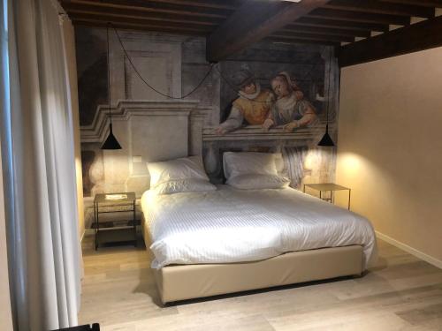 a bedroom with a bed with a painting on the wall at Villa Cantoni Marca in Sabbioneta