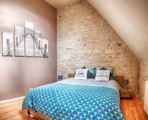 a bedroom with a bed with two pictures on the wall at LA FERME DES NONAINS in Montjavoult