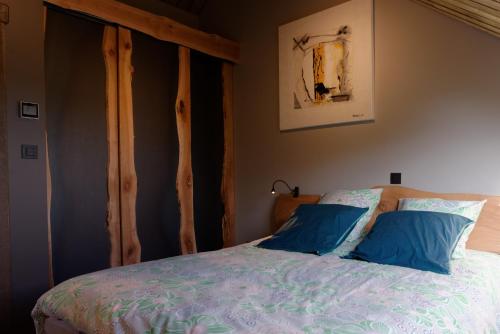 a bedroom with a bed with blue pillows at la Nouchettière in La Roche-en-Ardenne