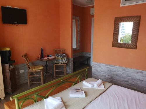 a room with a bed and a table and a television at La Rosa dei Venti Resort in Piombino