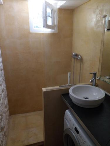 une salle de bain avec un lavabo et une machine à laver dans l'établissement Mazet du ruisseau, aux Baux-de-Provence