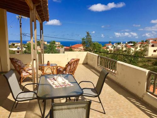 a patio with a table and chairs on a balcony at Goldy's Villa in Roussospítion