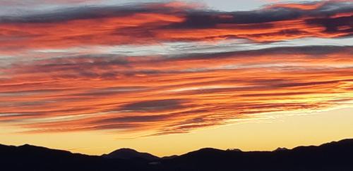 a sunset with clouds in the sky over mountains at Wein- und Weitblick in Gleinstätten