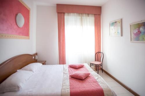 a bedroom with a bed, desk, chair and lamp at Hotel Europa in Modena