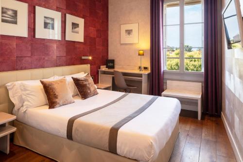 a hotel room with a bed and a window at Hotel des Arceaux in Montpellier