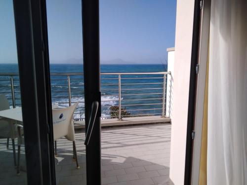 een kamer met uitzicht op de oceaan vanaf een balkon bij La Rosa dei Venti Resort in Piombino