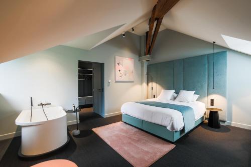 a bedroom with a large bed with a blue headboard at Hôtel Vedette in Profondeville