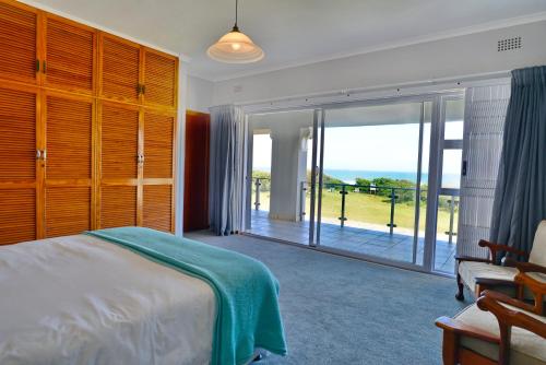a bedroom with a bed and a large sliding glass door at Cannon House in Cannon Rocks