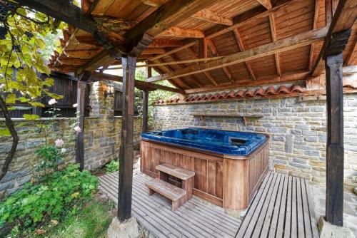 a hot tub on a patio with a wooden roof at Villa Fiikova in Medven