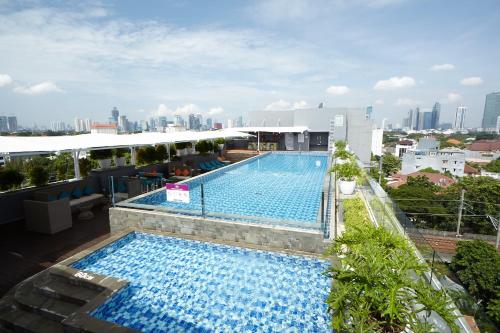einen Blick über den Pool auf einem Gebäude in der Unterkunft Mercure Jakarta Cikini in Jakarta