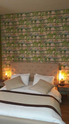 a bed with white pillows and a brick wall at Hotel Le Griffon in Abidjan