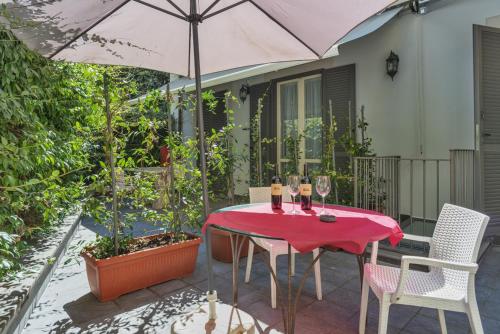 a table with wine glasses and an umbrella on a patio at Etruria Relais and Wine in Rome