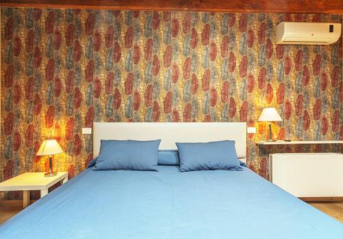 a bedroom with a blue bed and a colorful wall at Etruria Relais and Wine in Rome