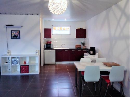uma cozinha com mesa e cadeiras num quarto em Le Soleil en Gironde em Vrillant