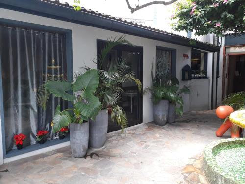 a house with three potted plants on a patio at Hotel Le Griffon in Abidjan