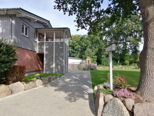 a house with a tree and a driveway at Strohböhn in Oldendorf