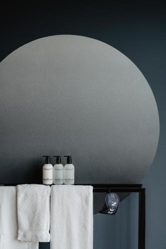a bathroom mirror with white towels on a rack at The Nox Hotel in Utrecht