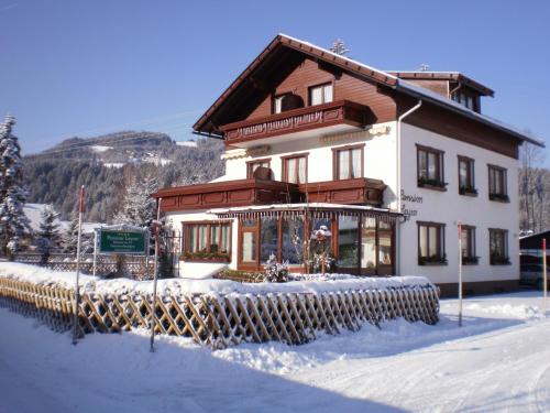 a large house in the snow with a fence at Pension Leyrer in Kötschach