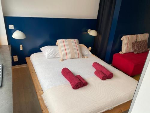 - 2 lits dans une chambre avec des serviettes rouges dans l'établissement Studio Peralta, à Liège