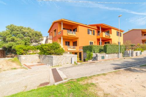 a yellow house with a fence in front of it at Conchiglia Verde in Barrabisa