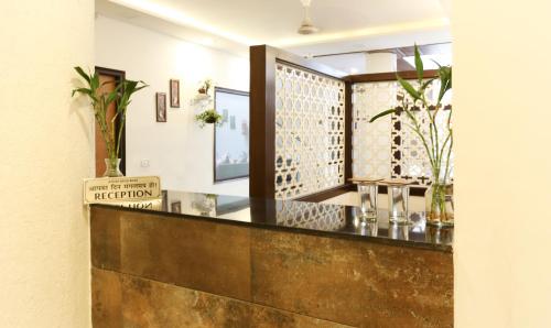 a bar with a wooden counter with vases on it at Hotel Seven- Center of City Chandigarh in Chandīgarh