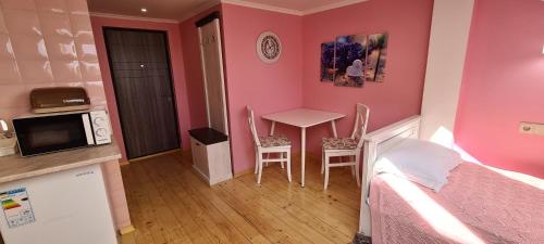 een kleine kamer met een bed en een tafel en stoelen bij Аpartment for Lady in Tsjernivsi