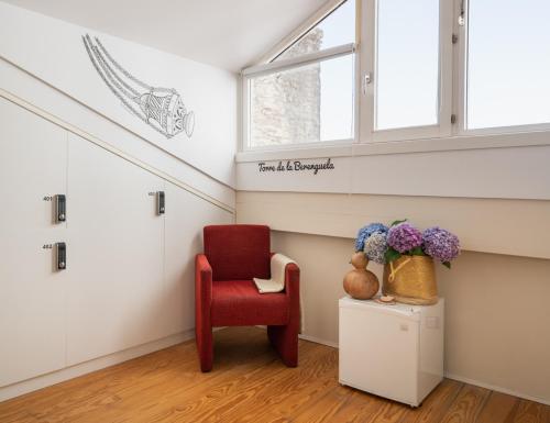 a red chair in a room with a window at Albergue The Last Stamp in Santiago de Compostela