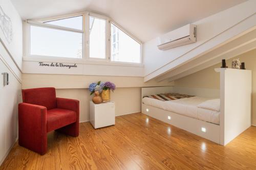 a bedroom with a bed and a red chair at Albergue The Last Stamp in Santiago de Compostela