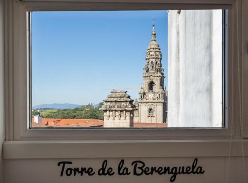 a window with a view of a building with a tower at Albergue The Last Stamp in Santiago de Compostela