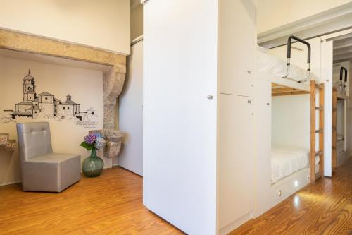 a bedroom with a bunk bed and a chair at Albergue The Last Stamp in Santiago de Compostela