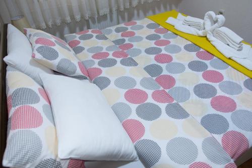 a bed with polka dot sheets and pillows at Apartment Elmari in Prilep