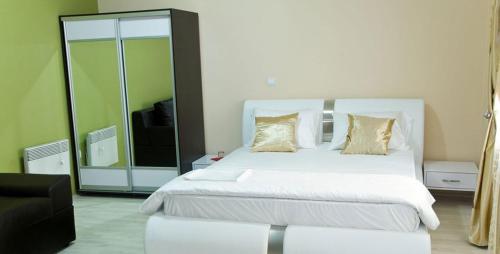 a bedroom with a large white bed and a couch at Hotel Leder in Kočani