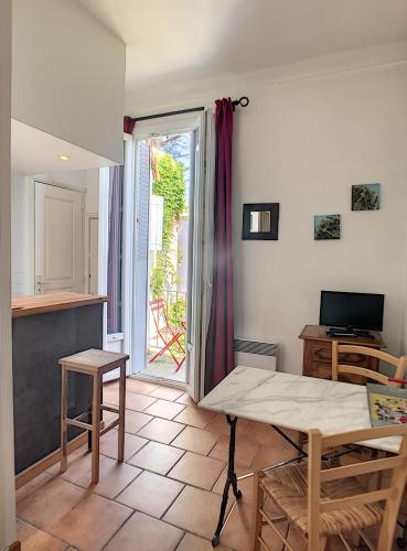 un salon avec une table et une télévision dans l'établissement Anne de la Maison Blanche, à Avignon