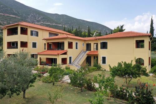 a house with a mountain in the background at Magda Hotel Apartments in Ancient Epidavros