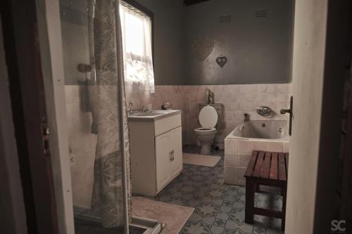 uma casa de banho com um WC, um lavatório e uma banheira em BlueCottage or Seaview Cottage at Coram Deo Lodge self catering em Coffee Bay