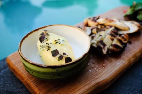 a bowl of food on a wooden cutting board at Anthemion Suites and Villas in Nafplio