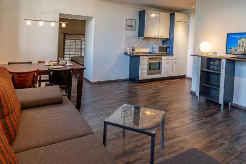 a living room and kitchen with a couch and a table at Hotel Birschel-Mühle in Hattingen