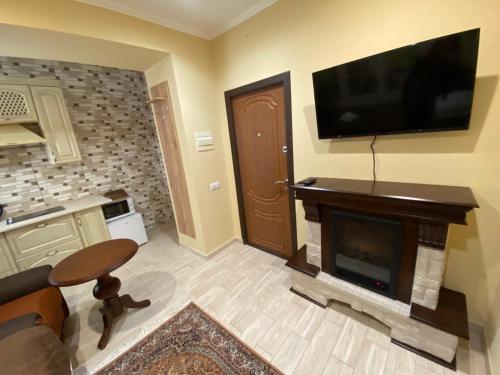 Man Apartment في تشيرنيفتسي: غرفة معيشة بها موقد وتلفزيون بشاشة مسطحة